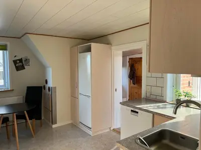 a kitchen with a sink and a refrigerator at Hyggeligt byhus in Harboør
