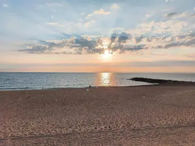 a beach with the sun setting over the ocean at 6 person holiday home in Vestervig-By Traum in Vestervig