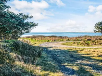 a dirt road leading to a body of water at 6 person holiday home in Vestervig-By Traum in Vestervig