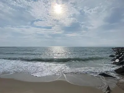 a beach with the sun shining on the water at 6 person holiday home in Vestervig-By Traum in Vestervig