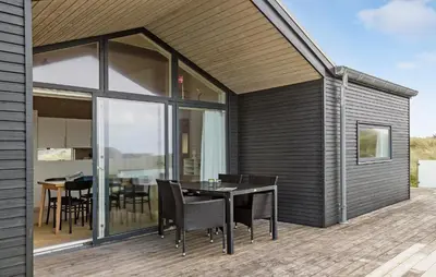 a patio with a table and chairs on a deck at Awesome Home In Løkken With Kitchen in Løkken