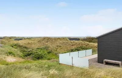a house on a hill with a wooden ramp and a bench at Awesome Home In Løkken With Kitchen in Løkken
