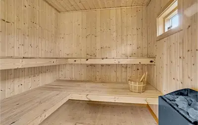 an empty wooden sauna with a bucket in it at Awesome Home In Løkken With Kitchen in Løkken