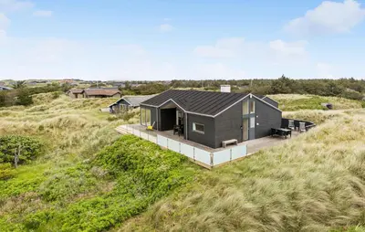 a house on a hillside with a deck at Awesome Home In Løkken With Kitchen in Løkken