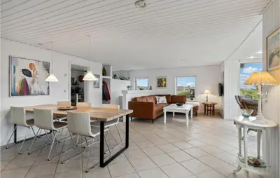 a kitchen and living room with a table and chairs at Stunning Home In Blokhus in Blokhus