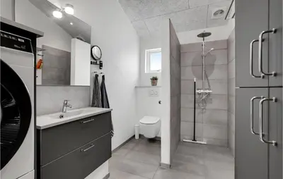 a bathroom with a shower and a sink and a toilet at Nice Home In Løkken With Sauna in Løkken