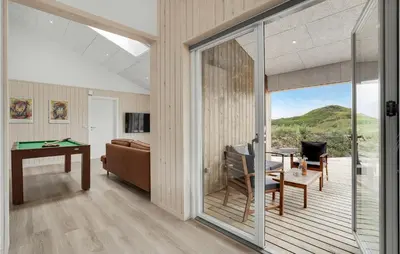 a living room with a pool table and a sliding glass door at Nice Home In Løkken With Sauna in Løkken