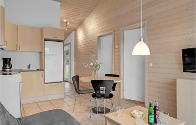 a kitchen and living room with a table and chairs at Stunning Home In Pandrup With Kitchen in Pandrup