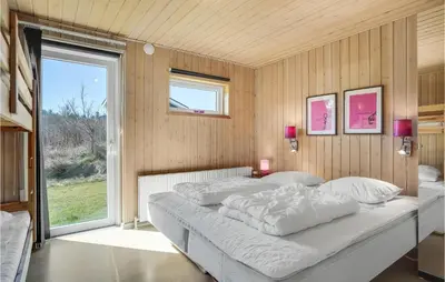 a bedroom with a bed and a large window at Gorgeous Home In Blokhus With Sauna in Blokhus