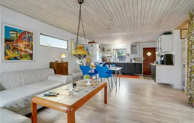 a living room with a couch and a table at 3 Bedroom Pet Friendly Home In Blokhus in Blokhus