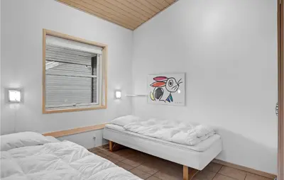 a bedroom with a bed and a window at 2 Bedroom Stunning Home In Pandrup in Pandrup