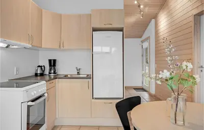 a kitchen with a table and a white refrigerator at Cozy Home In Pandrup With Wifi in Pandrup