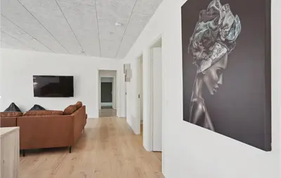a living room with a couch and a painting on the wall at Stunning Home In Blokhus With Kitchen in Blokhus