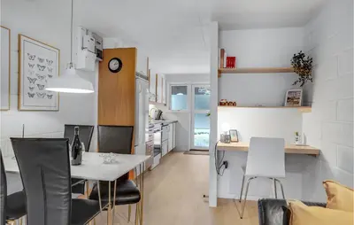 a kitchen and living room with a table and chairs at 2 Bedroom Cozy Apartment In Blokhus in Blokhus