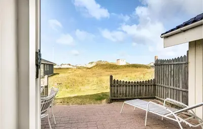 a patio with two chairs and a fence and a table at 3 Bedroom Gorgeous Home In Blokhus in Blokhus