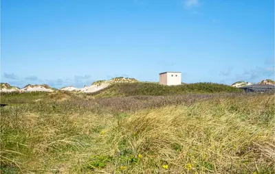 a small building on top of a grassy hill at 3 Bedroom Gorgeous Home In Blokhus in Blokhus