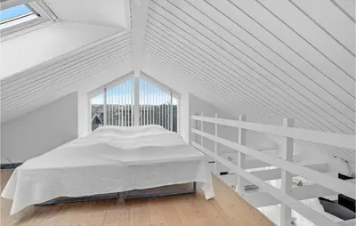 a white bedroom with a bed and a ladder at 3 Bedroom Gorgeous Home In Blokhus in Blokhus