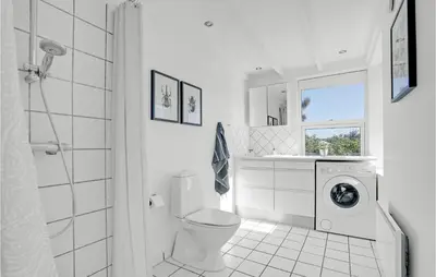 a white bathroom with a toilet and a washing machine at 3 Bedroom Gorgeous Home In Blokhus in Blokhus