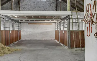 an empty garage with wooden doors and scaffolding at 3 Bedroom Stunning Home In Pandrup in Pandrup