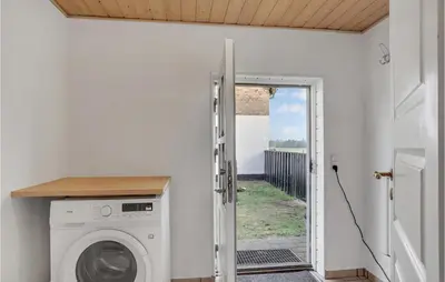 a washing machine in a room with a door at 3 Bedroom Stunning Home In Pandrup in Pandrup