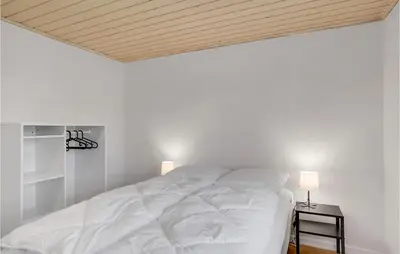 a white bed in a room with a wooden ceiling at 3 Bedroom Stunning Home In Pandrup in Pandrup