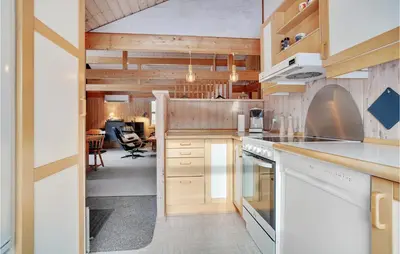 a kitchen with white appliances and a dining room at 3 Bedroom Gorgeous Home In Pandrup in Pandrup