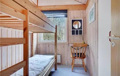 a bedroom with two bunk beds and a chair at 3 Bedroom Gorgeous Home In Pandrup in Pandrup