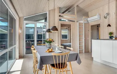 a kitchen and dining room with a table and chairs at Nice Home In Blokhus With Kitchen in Blokhus