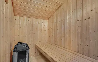 a wooden sauna with a trash can in it at Nice Home In Blokhus With Kitchen in Blokhus
