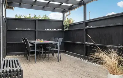 a patio with a table and chairs and a fence at Nice Home In Thisted With Kitchen in Thisted
