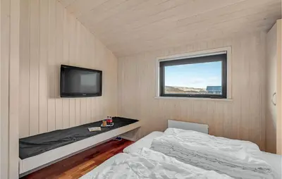 a small bedroom with a bed and a television at 3 Bedroom Awesome Home In Harboøre in Harboør
