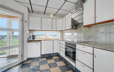 a kitchen with white cabinets and a large window at Lovely Home In Harboøre With Sauna in Harboør