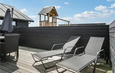 a group of chairs and an umbrella on a deck at Lovely Home In Thisted With Sauna in Thisted