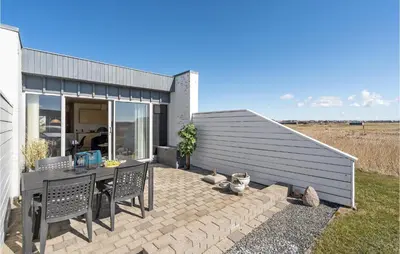a patio with a table and chairs next to a building at Amazing Home In Vestervig With Sauna in Vestervig