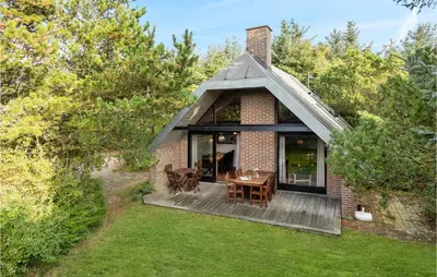 a small brick house with a table on a deck at Cozy Home In Vestervig With Sauna in Vestervig