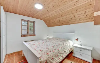 a bedroom with a bed and a wooden ceiling at Cozy Home In Vestervig With Sauna in Vestervig