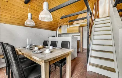 a dining room with a wooden table and black chairs at Cozy Home In Vestervig With Sauna in Vestervig