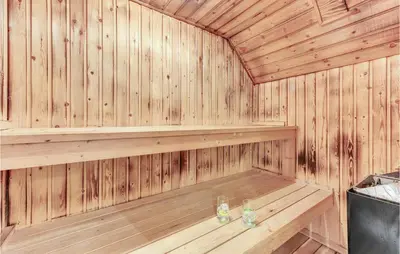 a wooden sauna with two wine glasses in it at Cozy Home In Vestervig With Sauna in Vestervig