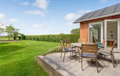 a patio with a table and chairs in a yard at Awesome Home In Vestervig With Wifi in Vestervig