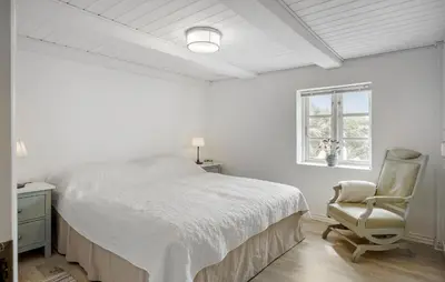 a white bedroom with a bed and a chair at Gorgeous Home In Lemvig With Sauna in Lemvig