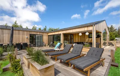 a wooden deck with chairs and a house at Cozy Home In Thisted With Sauna in Thisted