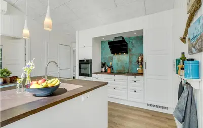 a white kitchen with a bowl of fruit on a counter at Cozy Home In Thisted With Sauna in Thisted