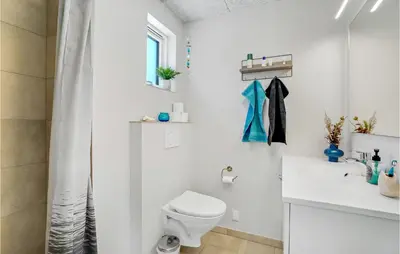 a white bathroom with a toilet and a sink at Cozy Home In Thisted With Sauna in Thisted