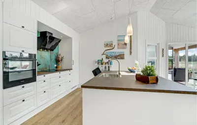 a kitchen with white cabinets and a sink at Cozy Home In Thisted With Sauna in Thisted
