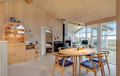 a dining room with a wooden table and chairs at Beautiful Home In Thyholm With Wifi in Thyholm