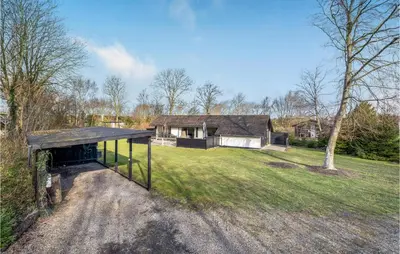 a house on a field with a dirt road at 3 Bedroom Awesome Home In Thyholm in Thyholm