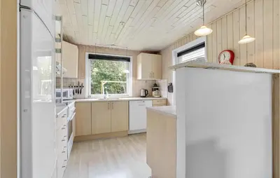 a kitchen with white appliances and a wooden ceiling at 3 Bedroom Amazing Home In Hurup Thy in Sindrup