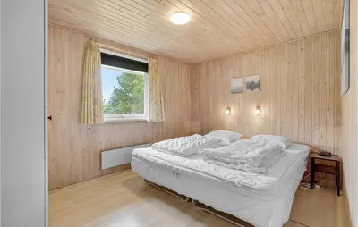 a bedroom with a bed in a wooden wall at 3 Bedroom Amazing Home In Hurup Thy in Sindrup