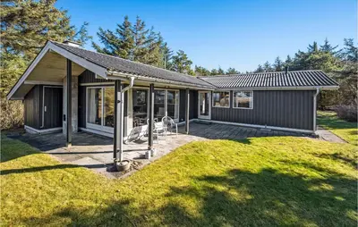 a small house with a deck in a yard at 3 Bedroom Gorgeous Home In Thyholm in Thyholm