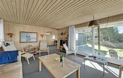 a living room with a couch and a table at 3 Bedroom Gorgeous Home In Thyholm in Thyholm